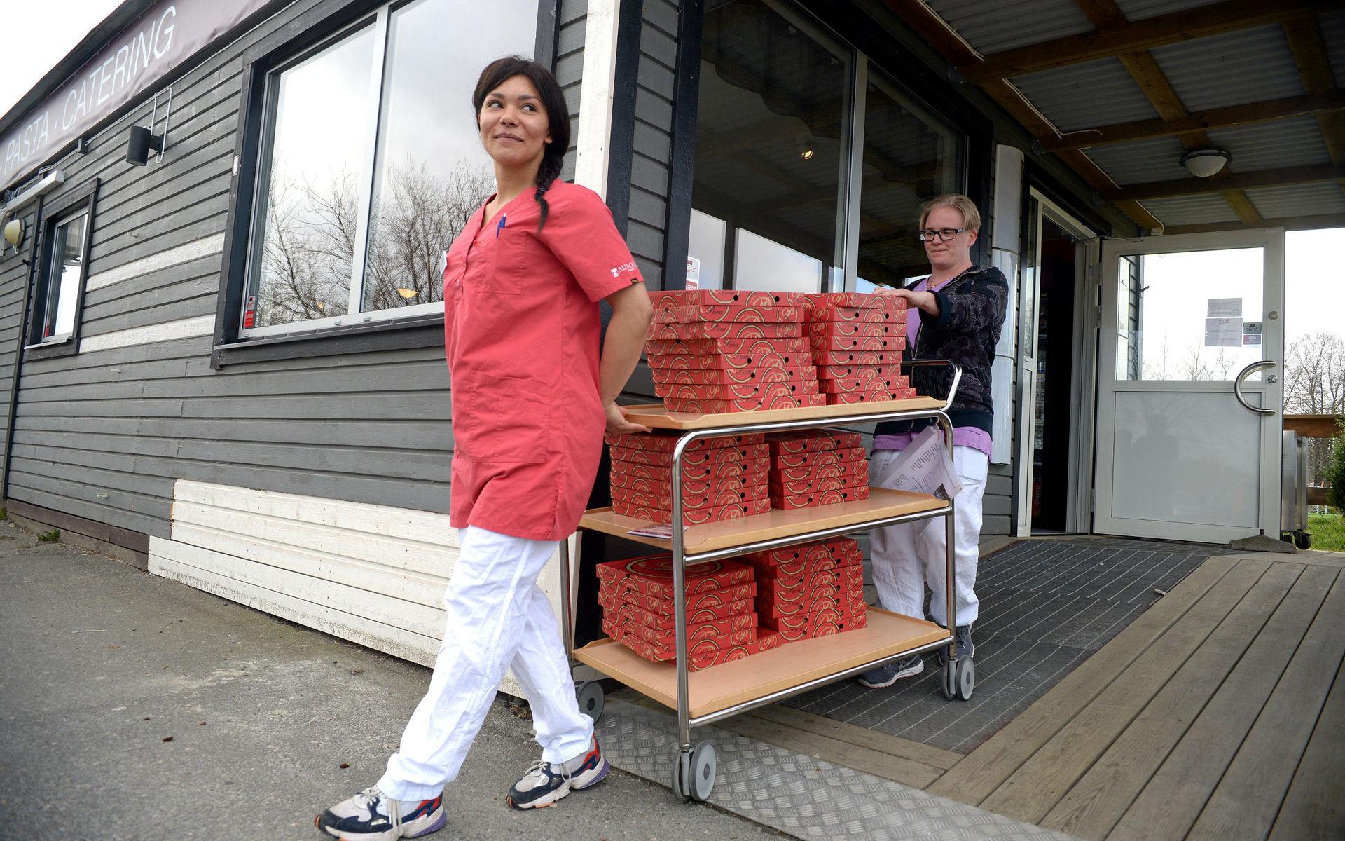 En vagn kommer lastad med gratispizza. Jenny Gustafsson och Nina Lennmark hjälps åt med påskdagens leverans från Da Riccardo. 