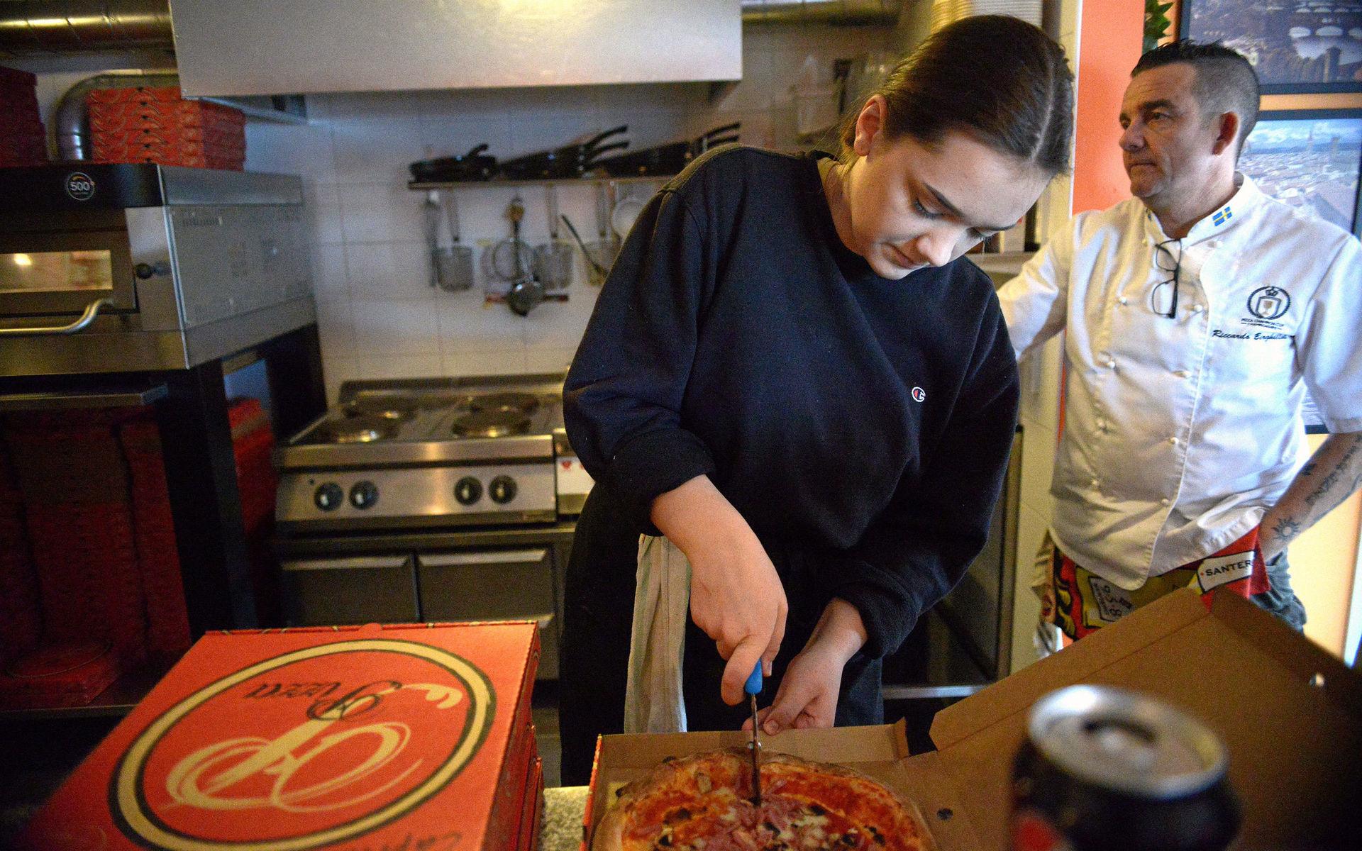 Thea Therning, en av pizzerians två anställda, slicar pizzor på löpande band. 