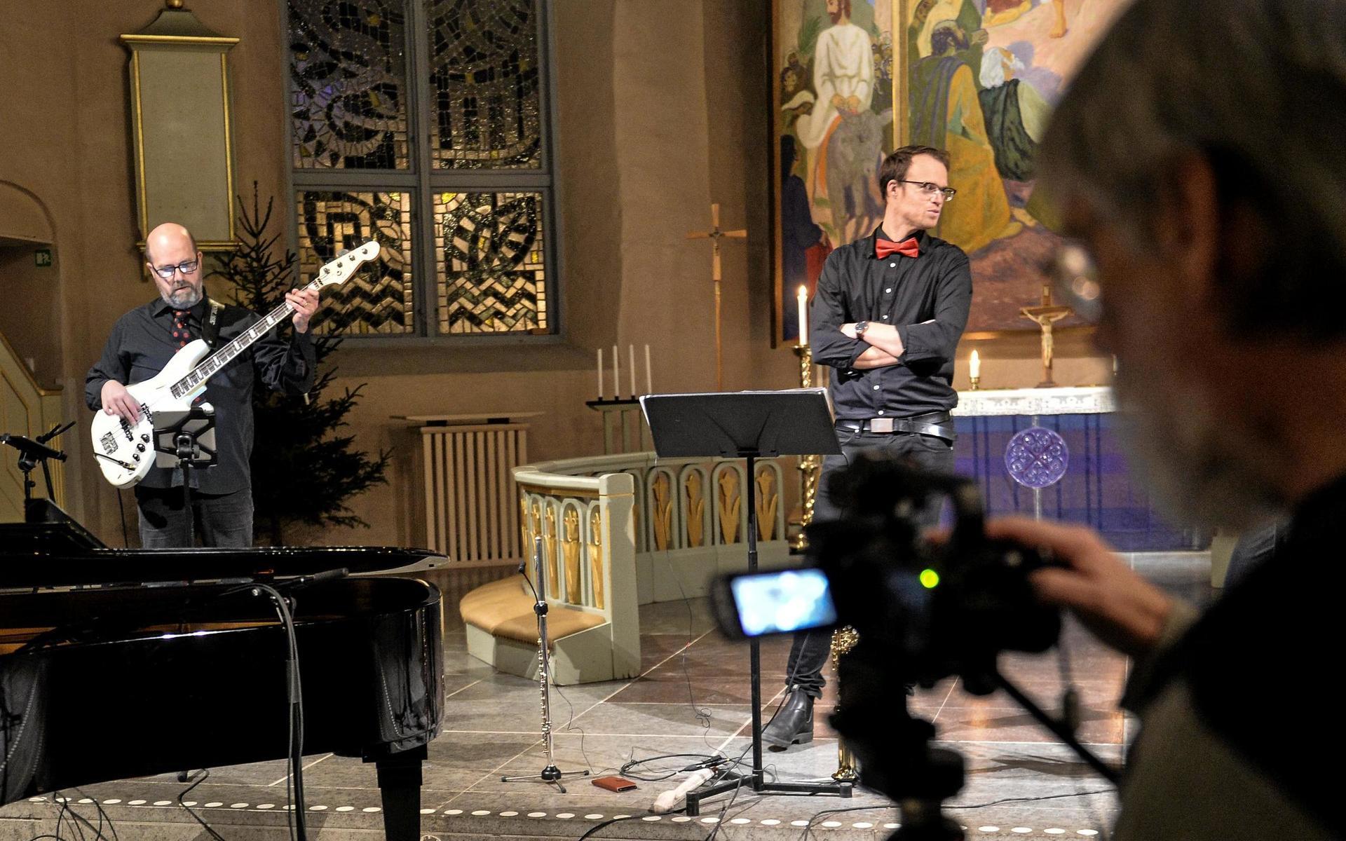 Svenska kyrkan i Alingsås anpassar sig till coronapandemin och sänder sina julkonserter på nätet. Här syns Kenneth Holmström på bas, Joel Hagen på flöjt/saxofon och kyrkomusikern Lollo Konnebäck bakom kameran.