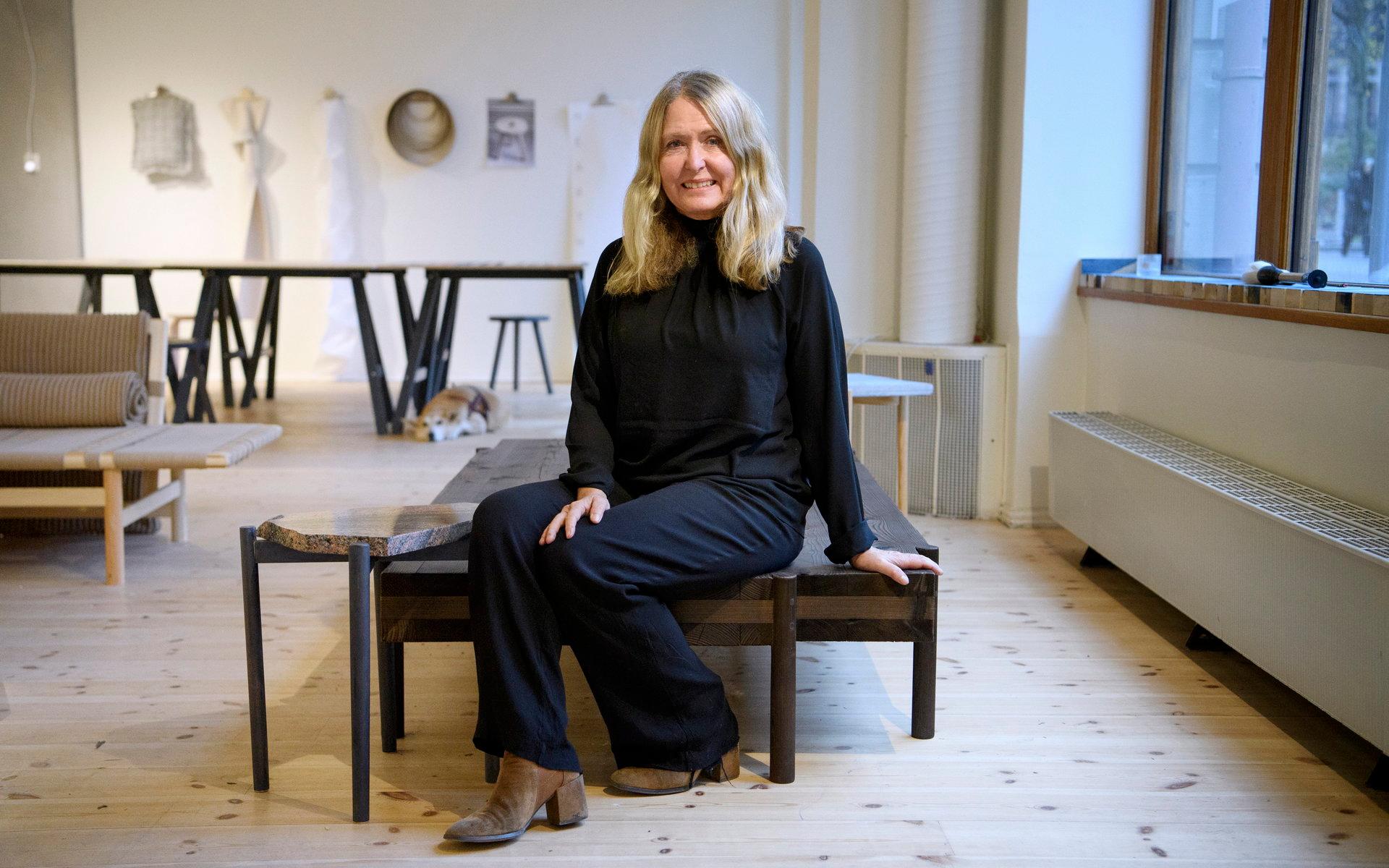 Upcyklingsdesigner Marie-Louise Hellgren sitter på en dagbädd som är tillverkad av fönsterurtagen från ett flerfamiljshus.