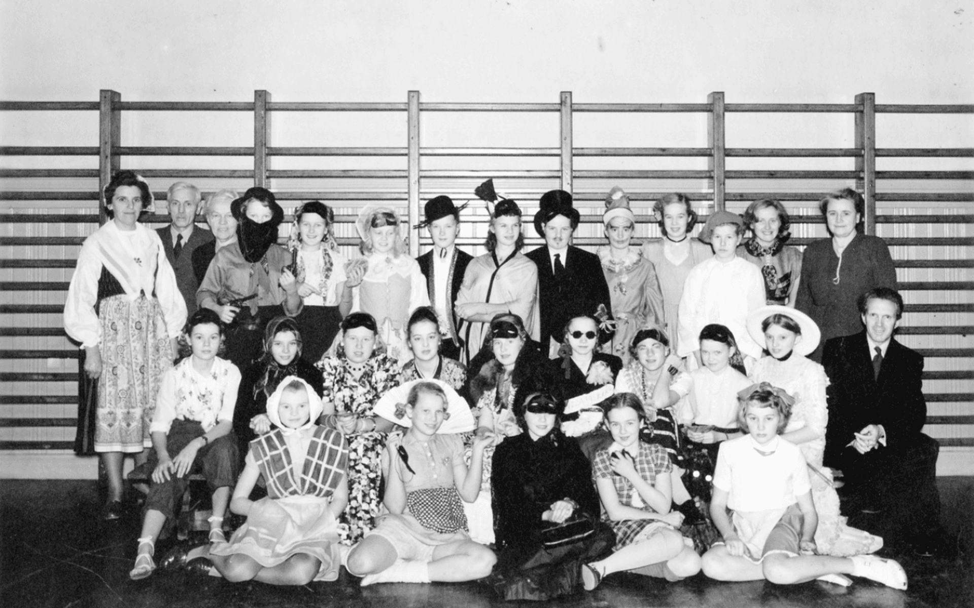 Maskerad i Norra skolan, utklädda elever och till höger, lärare Alfons Nilsson, till vänster övre raden, lärarparet Friskopp, sittande framför dem småskollärare Alice Eliasson. Fotot från omkring 1946.
