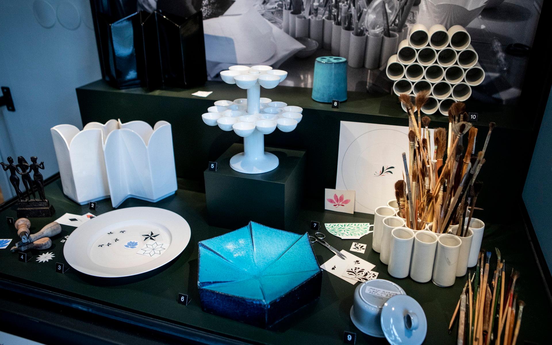 Karin Björquist donerade utvalda delar av sin produktion till Gustavsbergs Porslinsmuseum. Det blå penstället och fatet heter Konvex. De vita krukorna till höger är specialdesignade för att passa liljekonvaljer.