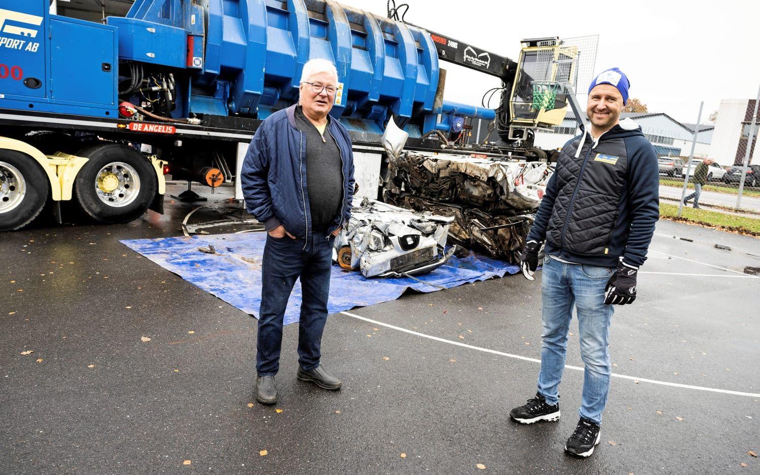 Bengt Abrahamsson och Christian Fåglum på Emtunga transport framför monstermaskinen de använde för att pressa ihop bilar till skrot.