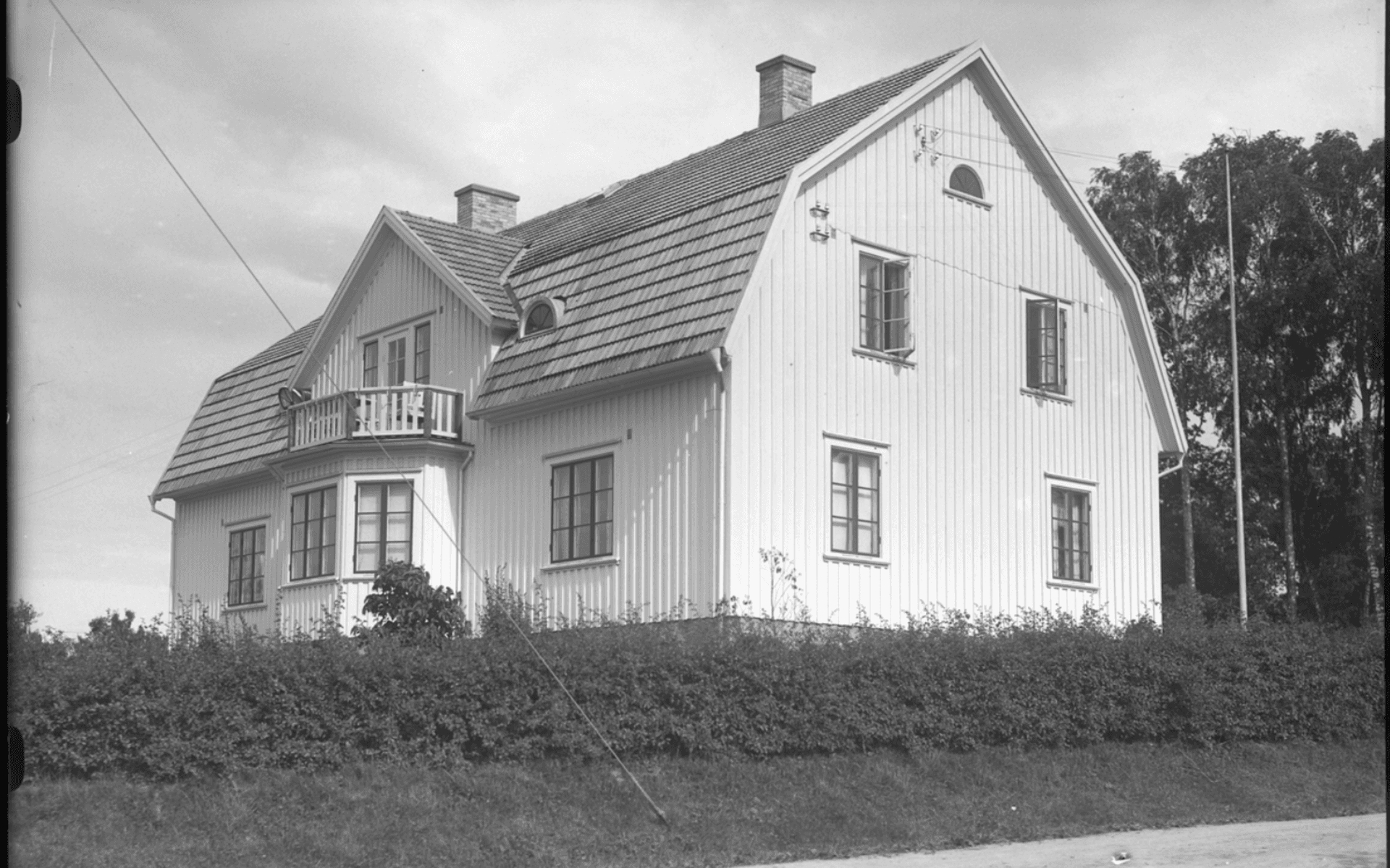 Villan Alfhem med ljus träpanel, burspråk och masard tak. Fotografering - 28 juli 1929.