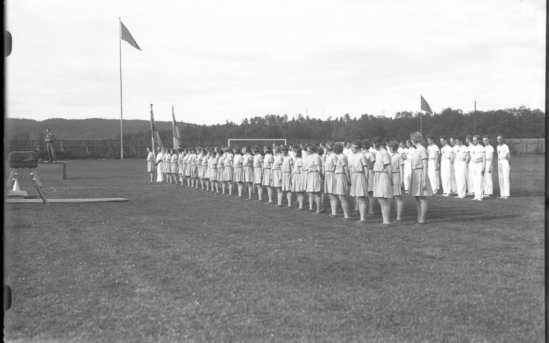 Gymnaster uppställda i rader på idrottsplatsen i samband med Gymnastikfesten. Fotografering - 1 juni 1930.