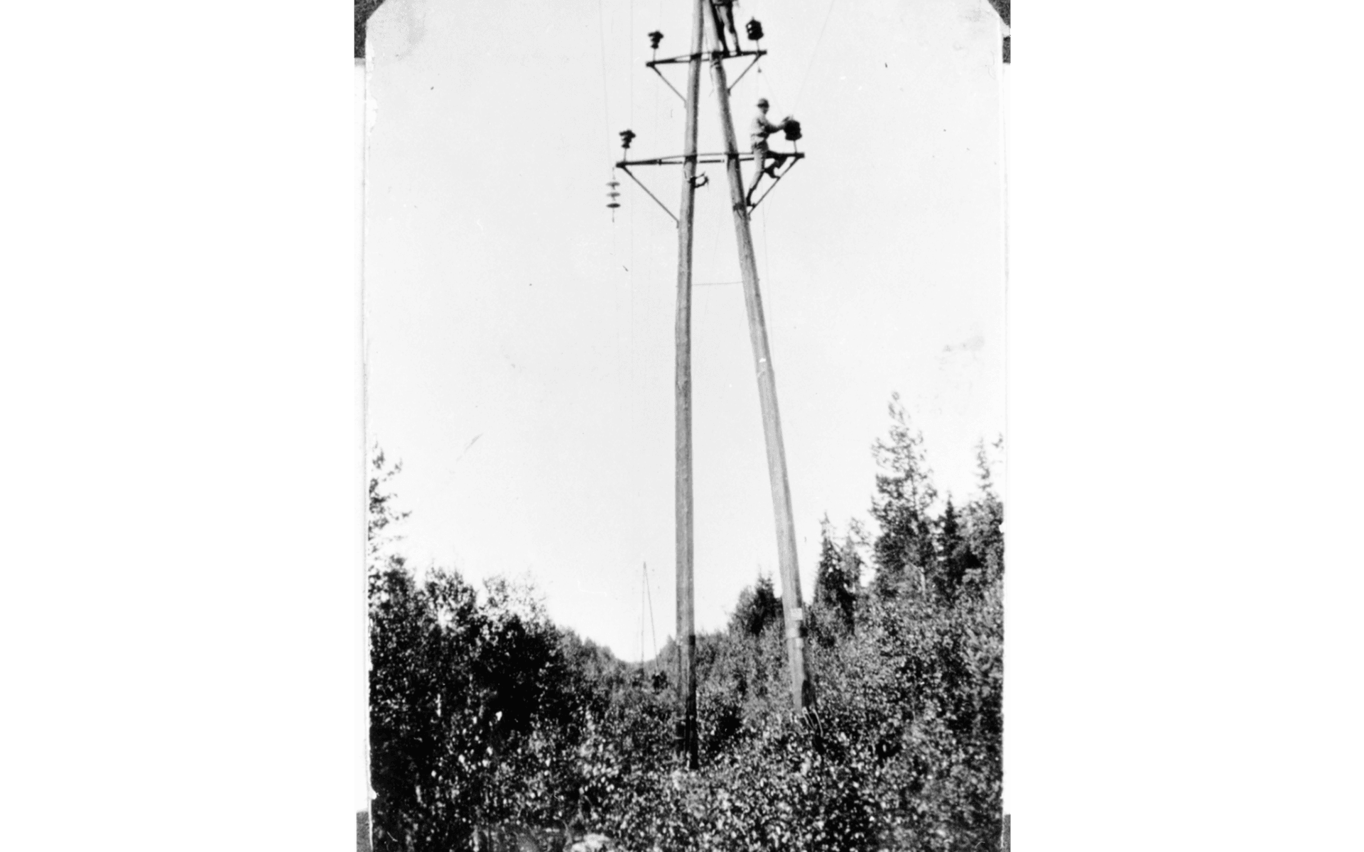 Två telearbetare i en telefonstolpe. Fotografering - 1920-1930.