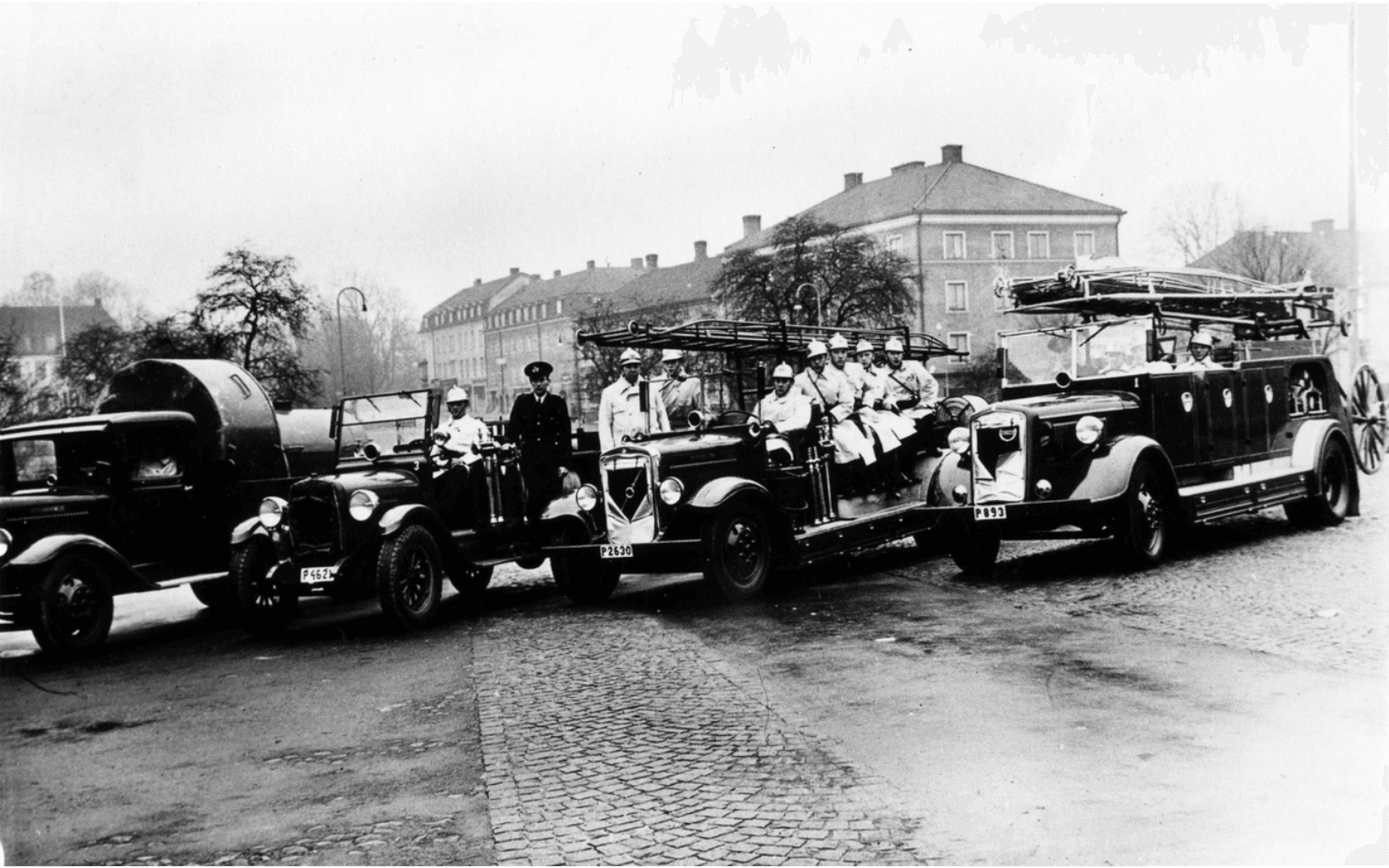 Brandkåren på Stora torget med fyra brandbilar: Från vänster: P4621 Chevrolet 1927, P2630 Volvo 1936 (kallad &quot;2:an&quot;), P893 1940 (1939), P893 1921 &quot;Tidaholm&quot;, samma nr hade den första brandbilen som levererades omkring 15/4 1921. Fotografering - 1945